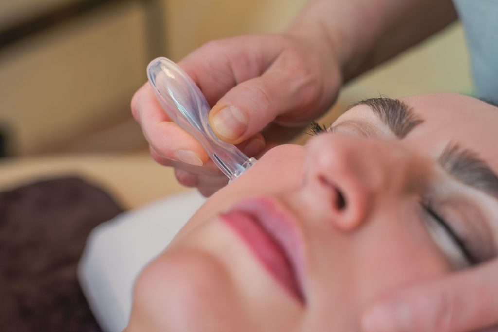 Nahaufnahme, wie Susan Mehr die obere Wange einer Kundin während der Schröpfmassage behandelt