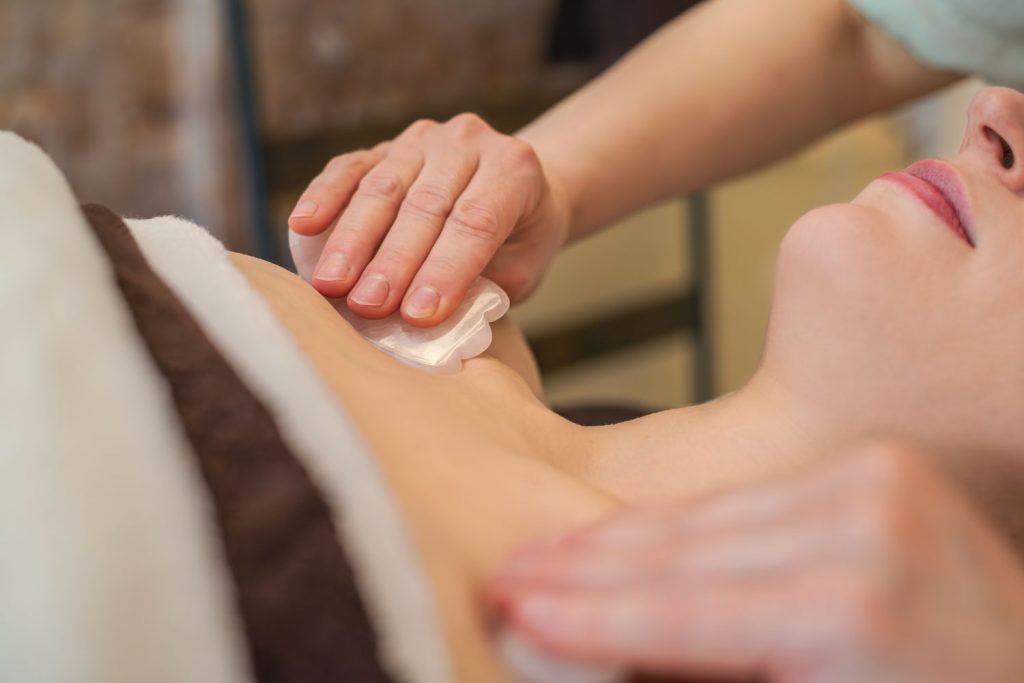 Der Bereich unterm Schlüsselbein wird während der Anti-Stress-Massage mit Gua Sha gelockert und entspannt