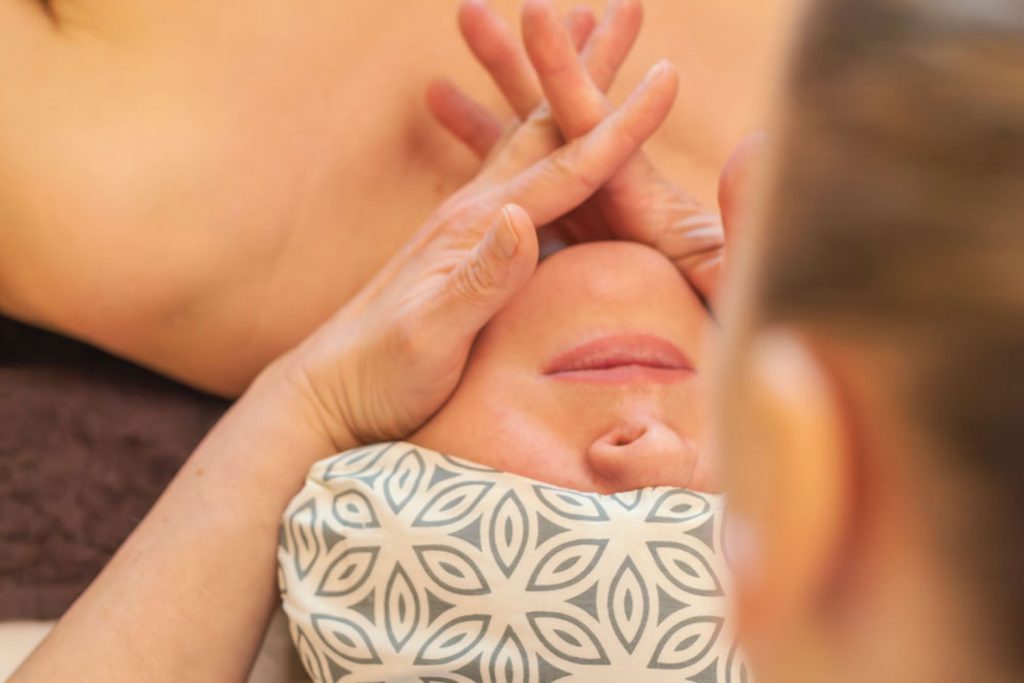 Wohltuende Gesichts- und Kiefermassage bei einer Frau als Teil der Anti-Stress-Massage